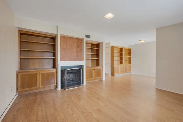 a view of an empty room with a fireplace and a window