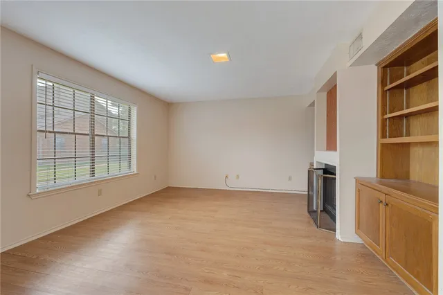 an empty room with closet and windows