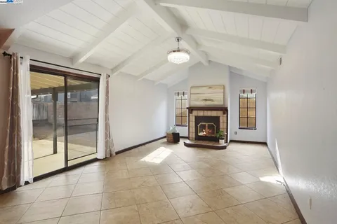a view of an empty room with a fireplace and a window