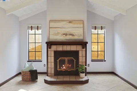 a living room with a fireplace and windows