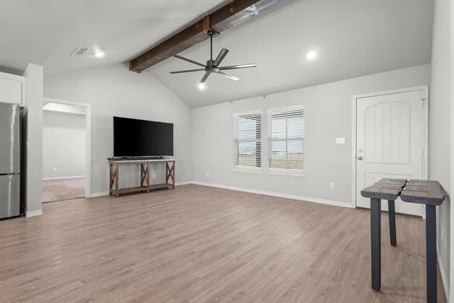 a living room with lots of furniture and kitchen view