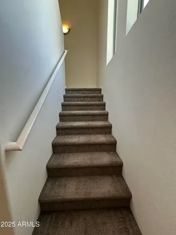 a view of an empty room with wooden floor and windows
