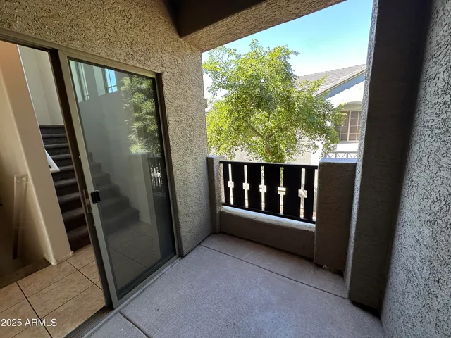 an empty room with windows and a chandelier fan