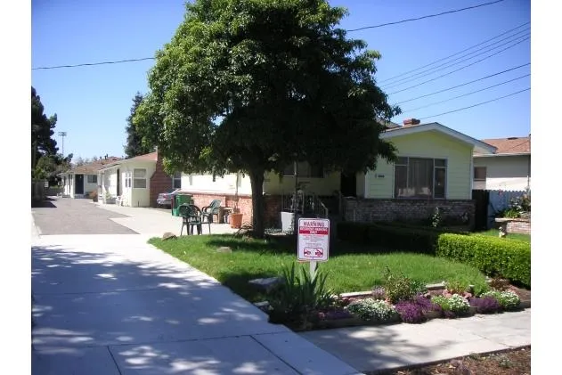 a front view of a house with a yard and potted plants
