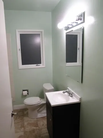 a bathroom with a toilet sink and mirror