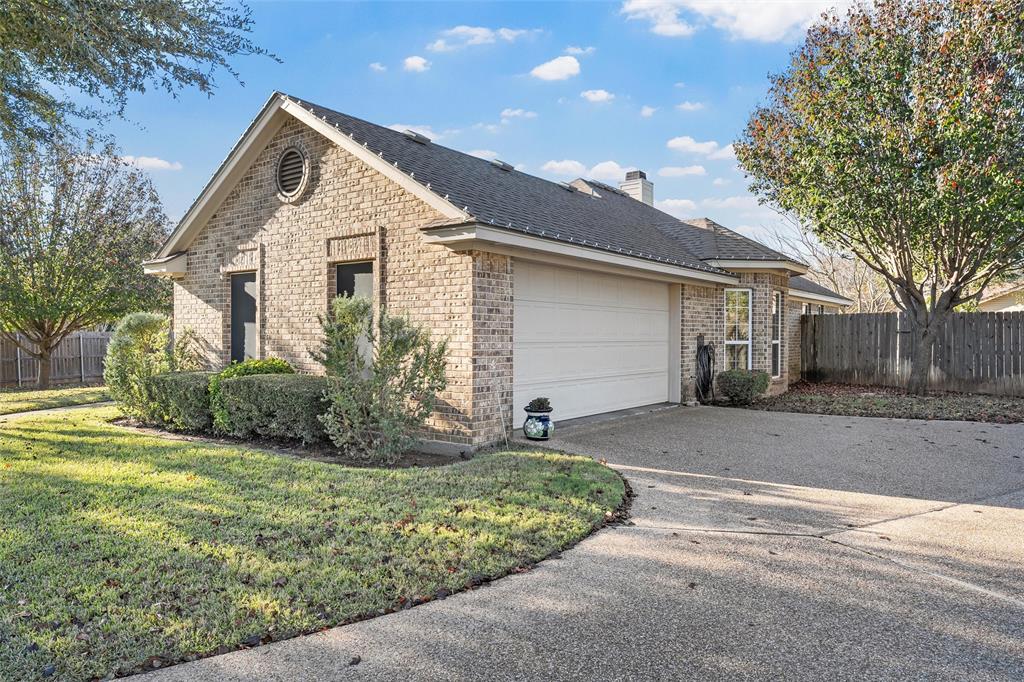 142 Phillip Circle Hewitt, TX 76643 - Photo 2 of 24 View of side of home featuring brick siding, driveway, a chimney, a shingled roof, and a garage