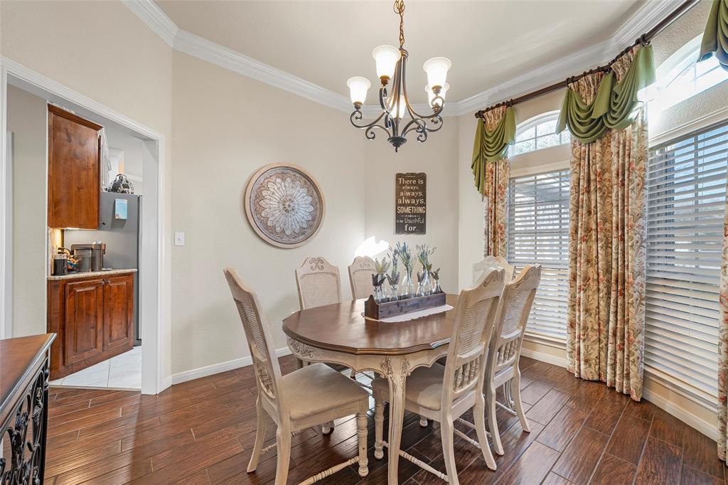 142 Phillip Circle Hewitt, TX 76643 - Photo 7 of 24 Dining area with healthy amount of natural light, wood finish floors, ornamental molding, and a chandelier
