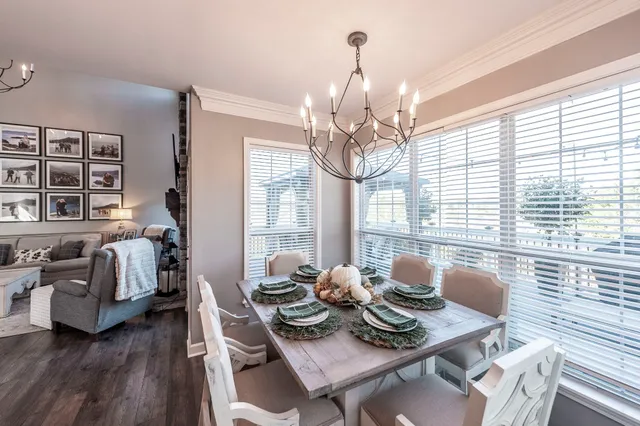 a view of a dining room with furniture a chandelier and wooden floor