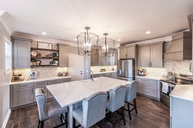 a kitchen with a dining table chairs refrigerator and cabinets