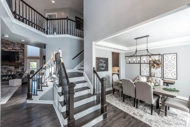 a view of a livingroom with furniture staircase and kitchen view