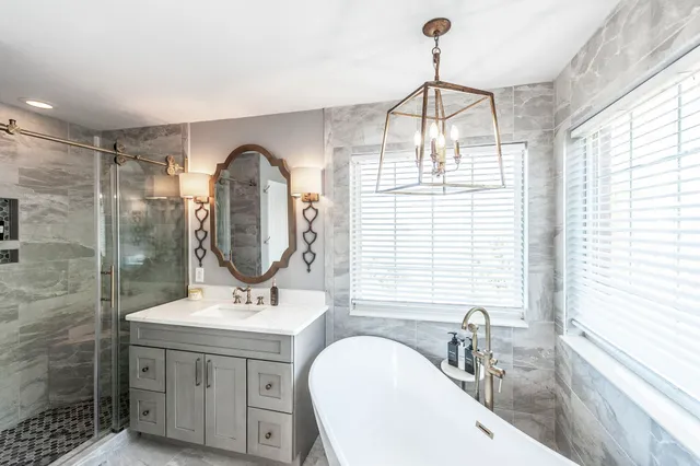 a bathroom with a sink a mirror a vanity and a shower