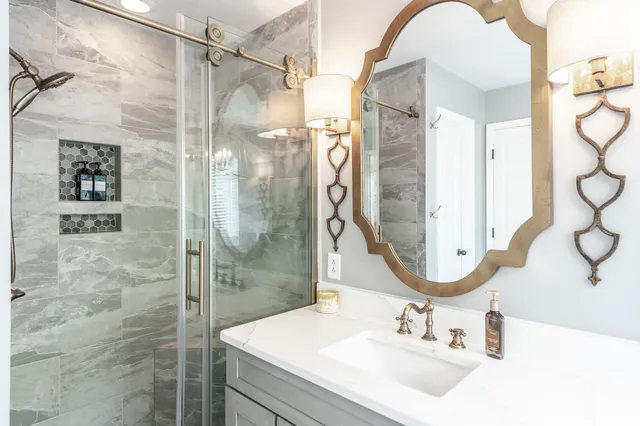 a bathroom with a sink shower and a mirror