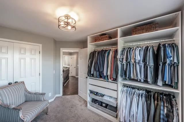 a view of walk in closet with clothes and shoes