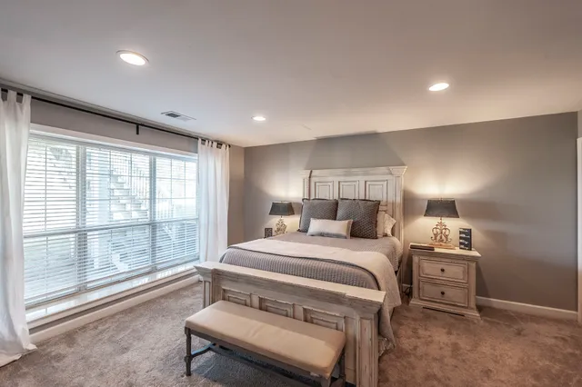 a bedroom with a bed and a large window