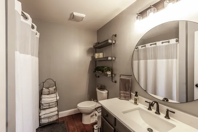 a bathroom with a sink a toilet and a mirror