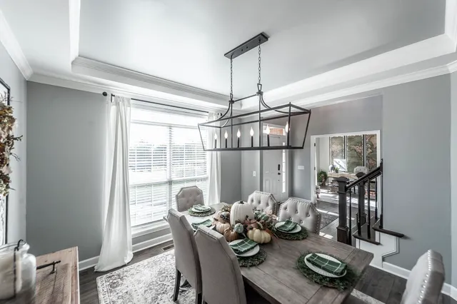 a front view of a dining room with furniture large window and wooden floor