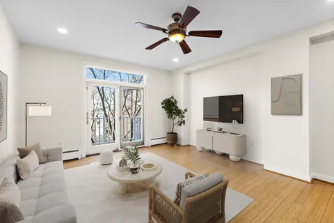 a living room with furniture a flat screen tv and a window