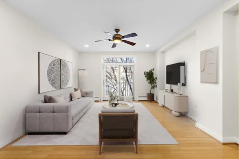 a living room with furniture a flat screen tv and a window