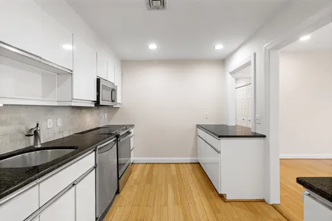 a kitchen with granite countertop a sink and cabinets