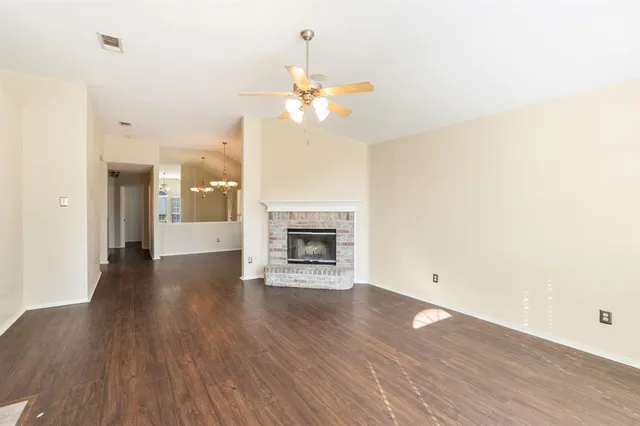 a view of a room with wooden floor and a ceiling fan