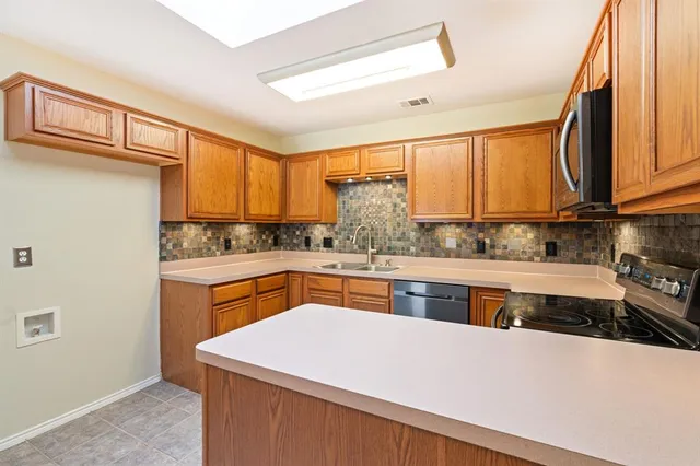 a kitchen with stainless steel appliances granite countertop a sink a stove and a refrigerator