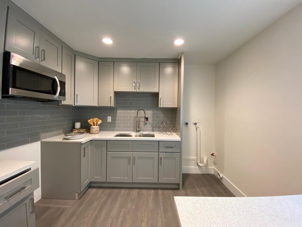 a kitchen with a sink a microwave and cabinets