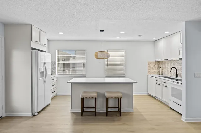 a kitchen with white cabinets and stainless steel appliances