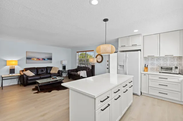 a kitchen with kitchen island a stove a sink and a refrigerator