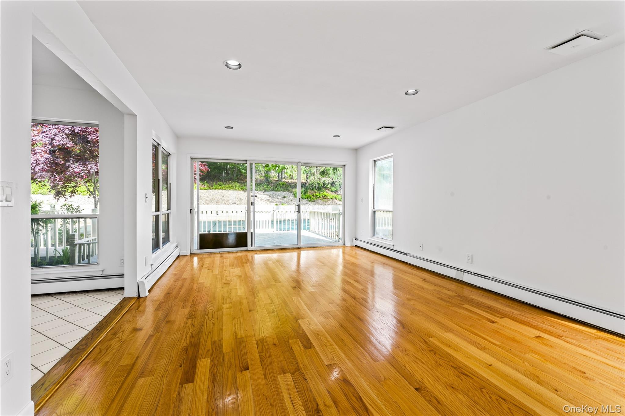 126 Bagatelle Road Melville, NY 11747 - Photo 10 of 50 a view of an empty room with wooden floor and a window