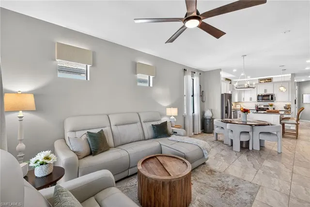 a living room with furniture a chandelier and a dining room