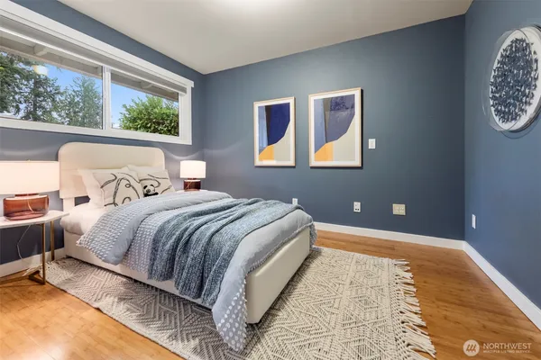 a bedroom with a bed and a painting on the wall