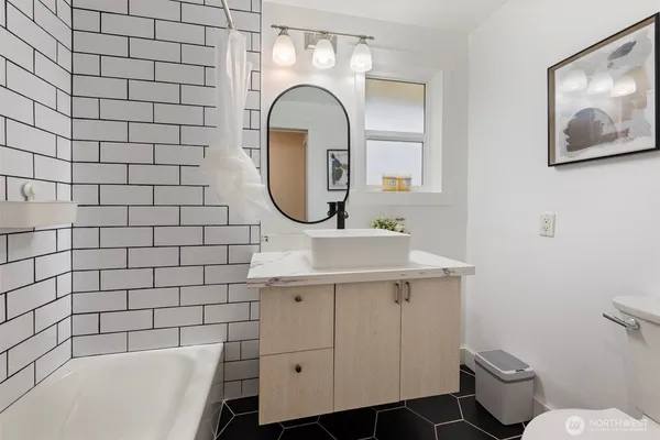 a bathroom with a sink mirror toilet and bathtub