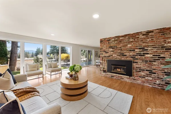 a living room with furniture a fireplace and a floor to ceiling window