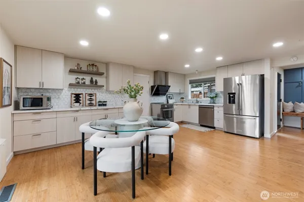a kitchen with refrigerator and wooden floor