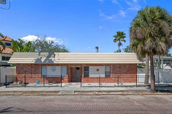 a row of palm trees in front of a house