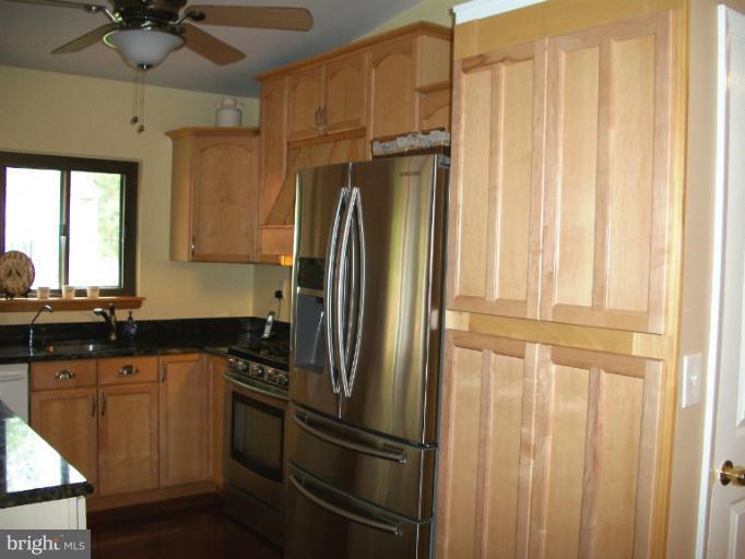 897 Beech Tree Road Severn, MD 21144 - Photo 22 of 30 a kitchen with a refrigerator a sink and cabinets