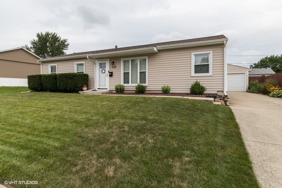 228 Murphy Drive Romeoville, IL 60446 - Photo 2 of 20 a front view of a house with a garden and yard