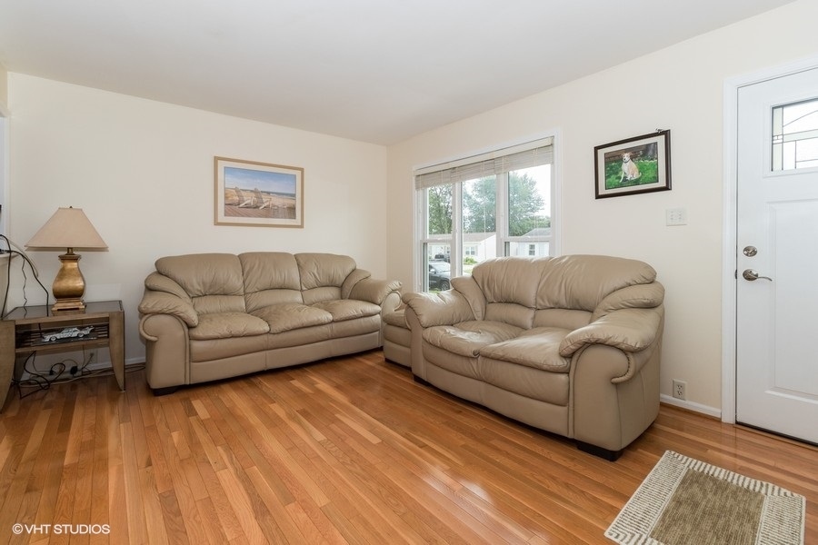 228 Murphy Drive Romeoville, IL 60446 - Photo 3 of 20 a living room with furniture and a wooden floor