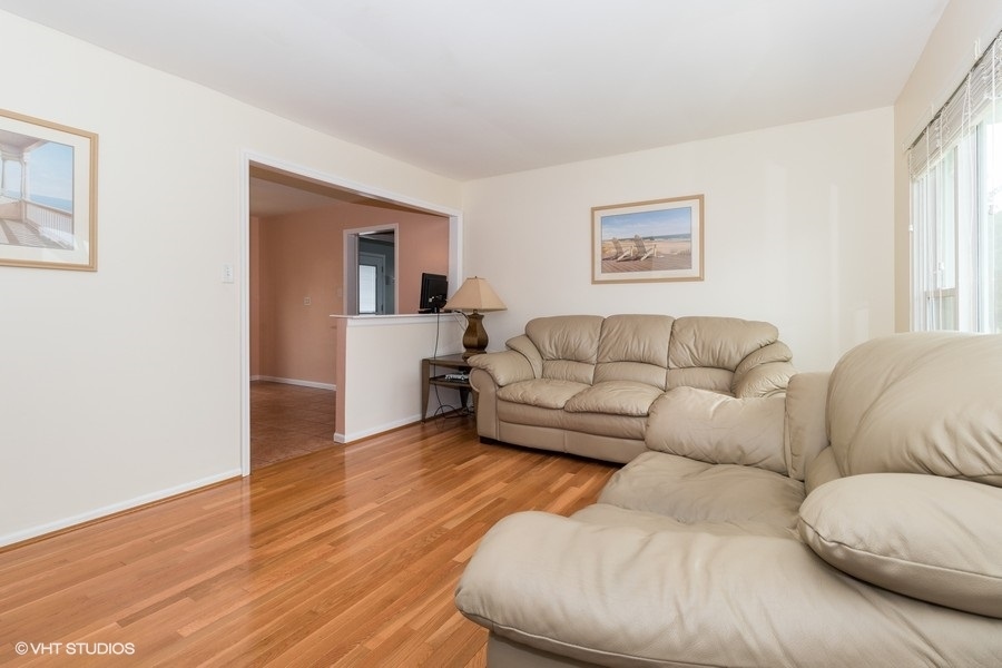 228 Murphy Drive Romeoville, IL 60446 - Photo 4 of 20 a living room with furniture and a wooden floor