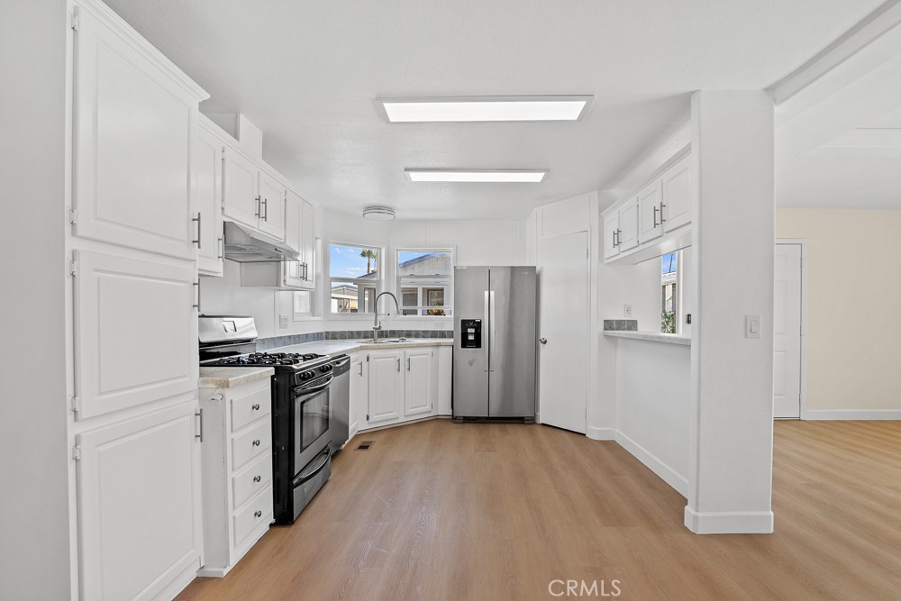 a kitchen with stainless steel appliances a white stove top oven and refrigerator