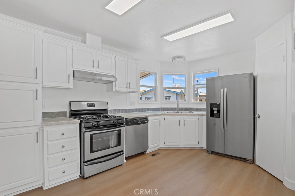 20401 Soledad Canyon Road, Unit 355 Canyon Country, CA 91351 - Photo 2 of 36 a kitchen with white cabinets and stainless steel appliances