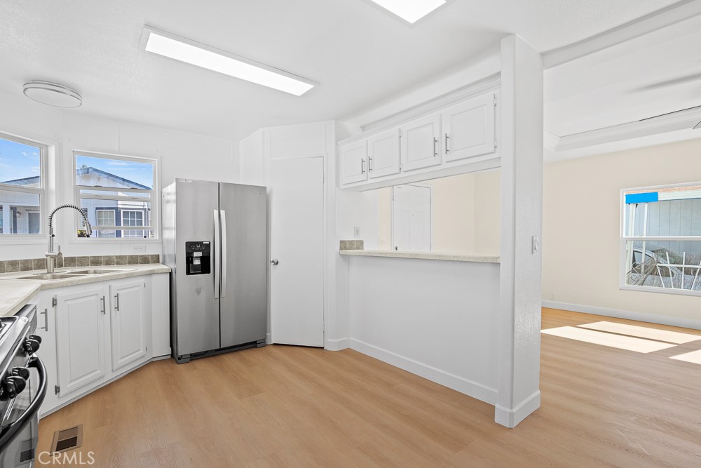 20401 Soledad Canyon Road, Unit 355 Canyon Country, CA 91351 - Photo 6 of 36 a view of a kitchen with refrigerator stove and wooden floor