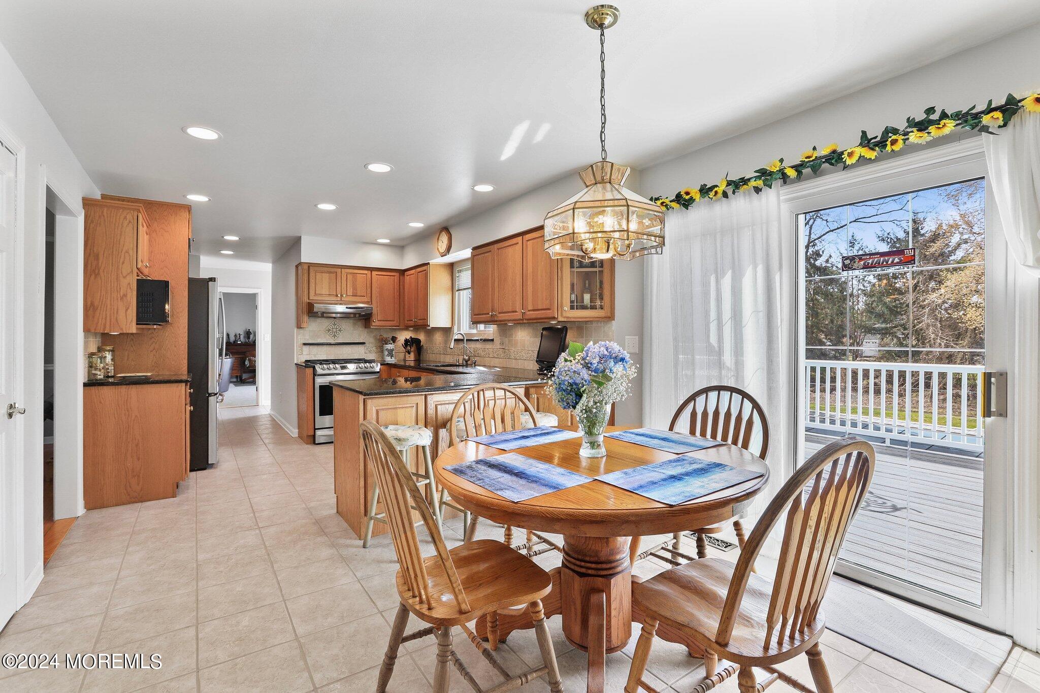 234 Yale Drive Lincroft, NJ 07738 - Photo 12 of 38 a view of a dining room and livingroom with furniture wooden floor a chandelier