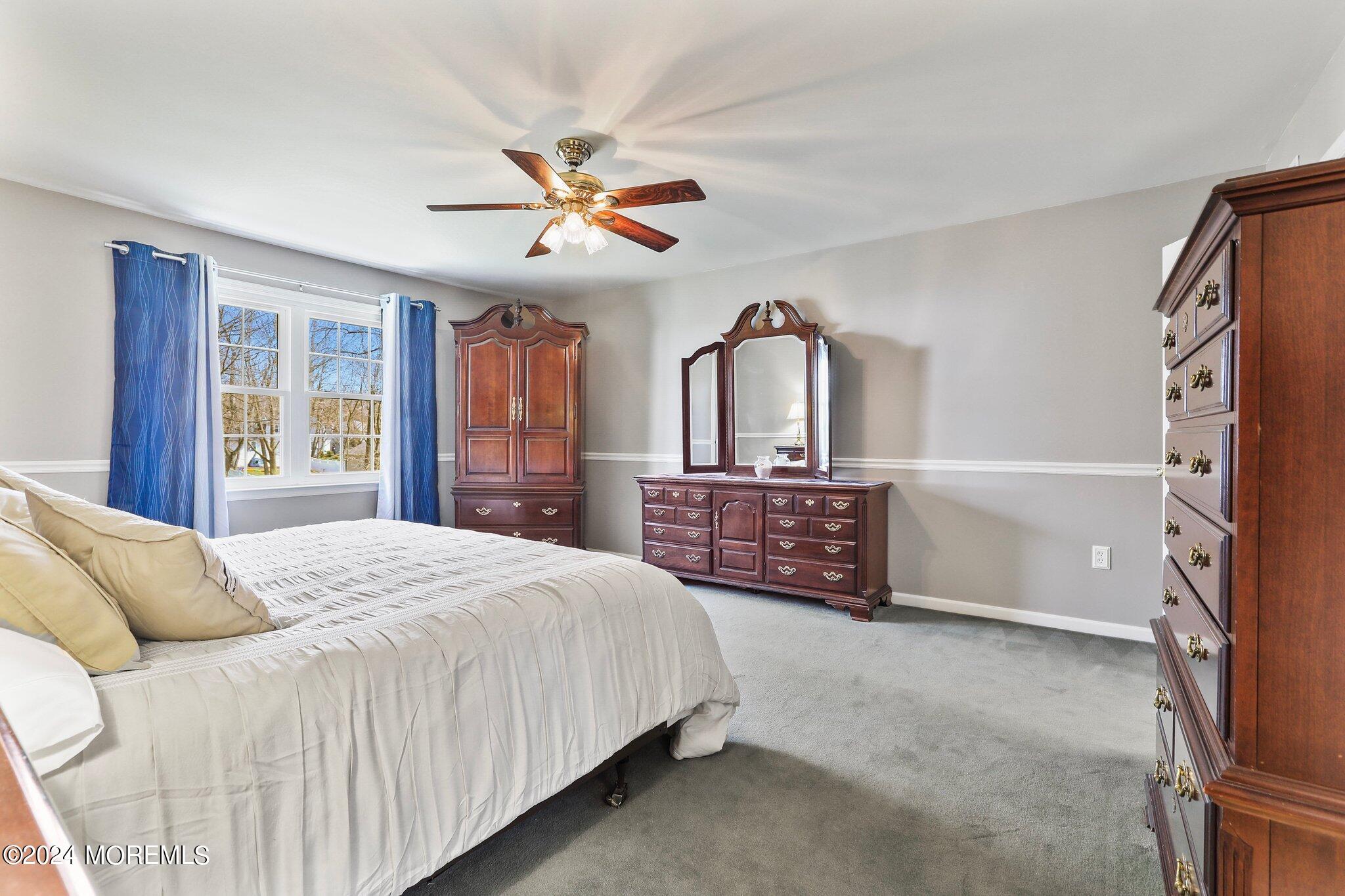 234 Yale Drive Lincroft, NJ 07738 - Photo 21 of 38 a spacious bedroom with a bed a dresser and a large window