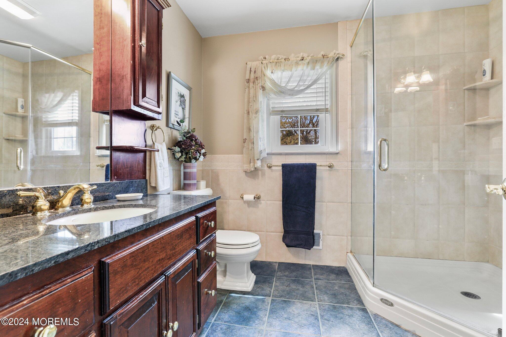234 Yale Drive Lincroft, NJ 07738 - Photo 23 of 38 a bathroom with a granite countertop sink a toilet a mirror and shower