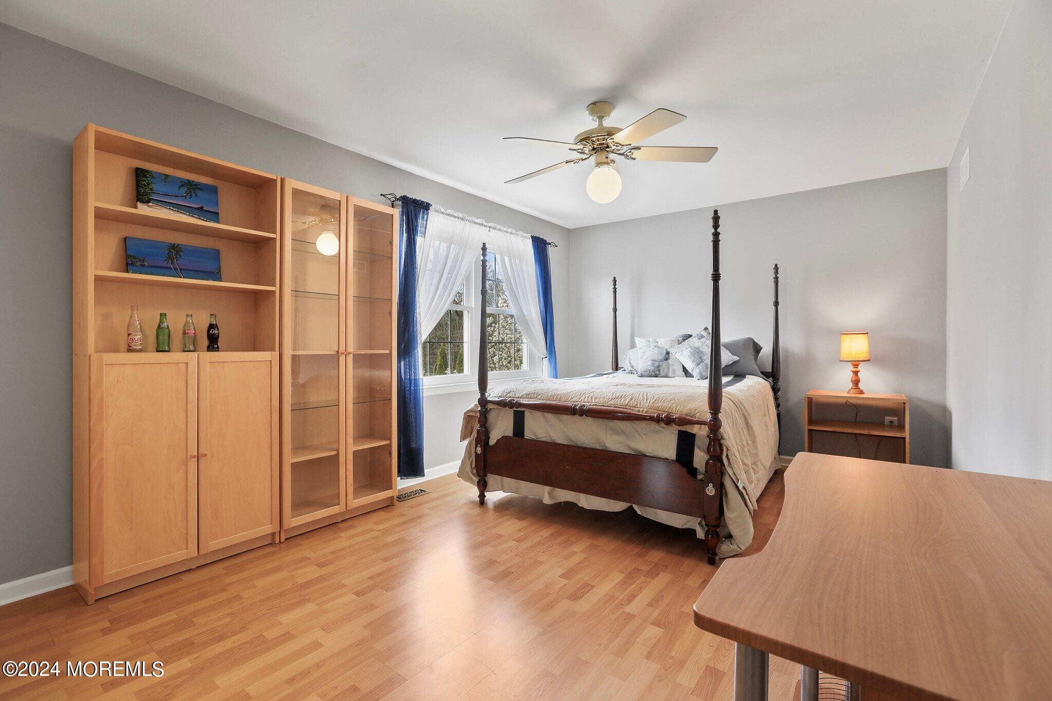 234 Yale Drive Lincroft, NJ 07738 - Photo 25 of 38 a bedroom with a bed a table and painting