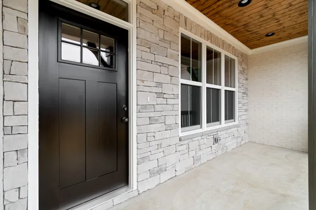 a kitchen with stainless steel appliances kitchen island granite countertop a stove a sink and white cabinets with wooden floor