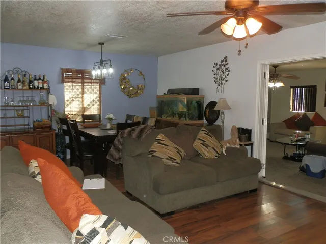 a living room with furniture a chandelier and a flat screen tv