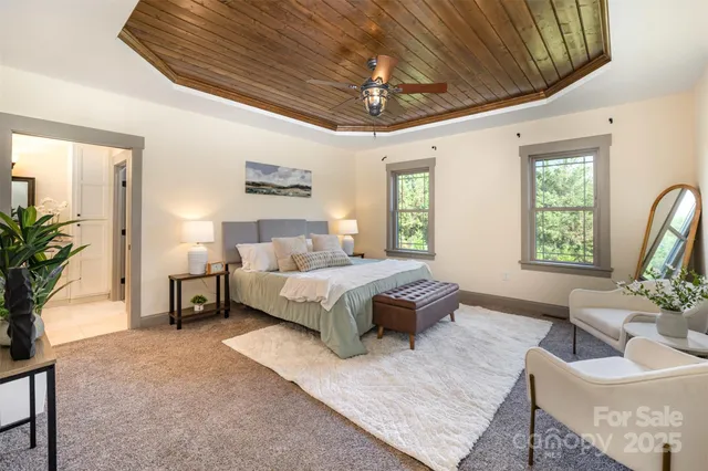 a spacious bedroom with a bed a couch and a potted plant