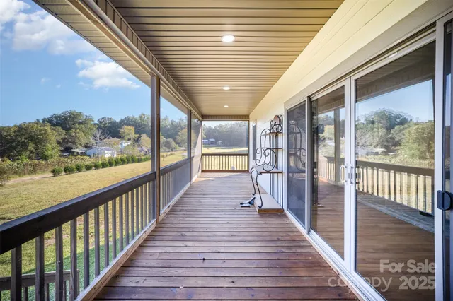 a view of a porch with wooden floor and outdoor seating